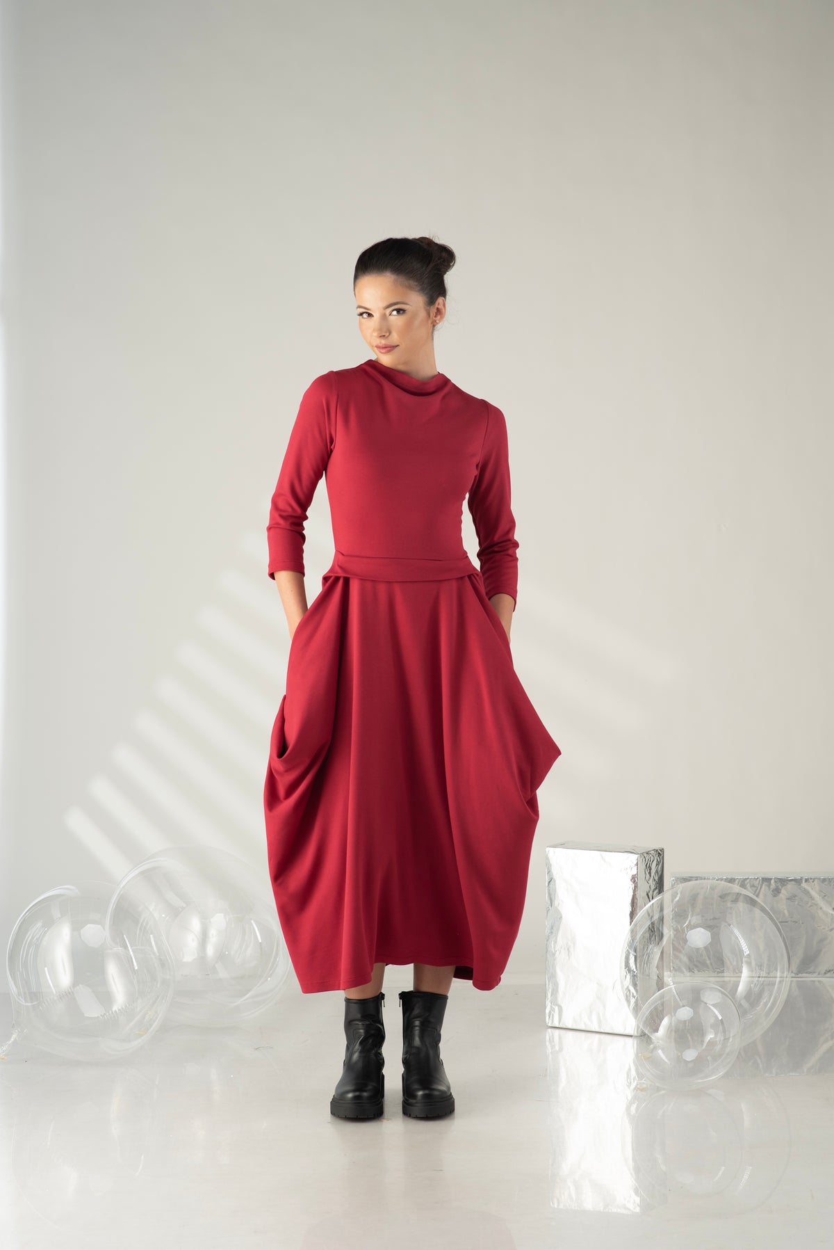 Woman wearing a red dress standing against a white background