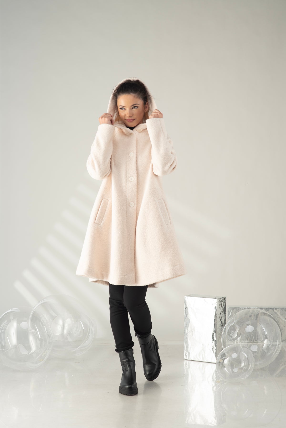 Cream women's hooded swing coat with front pockets and flared silhouette