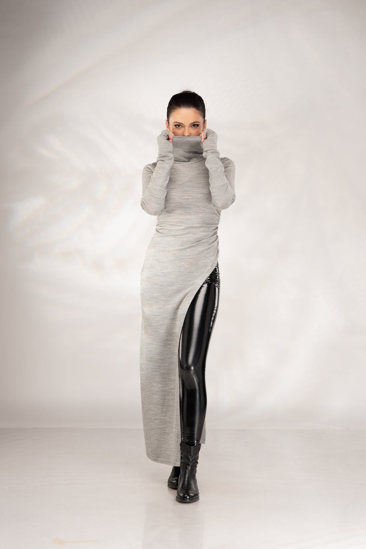Women's grey maxi sweater dress with high cowl neck and asymmetrical side slit, front view